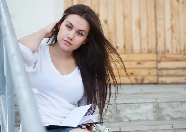 Young woman sitting on the stairs — Stock Photo, Image