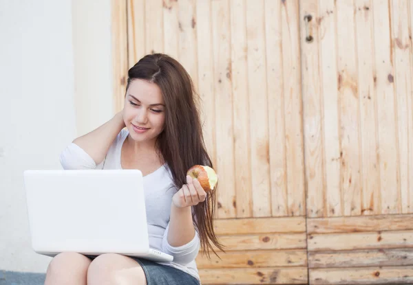 Menina com laptop e maçã — Fotografia de Stock