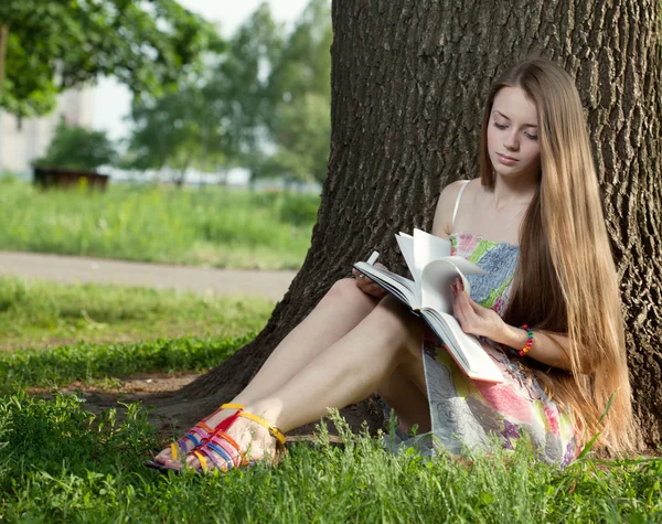 Teenager in a park with notebook — Stock Photo, Image