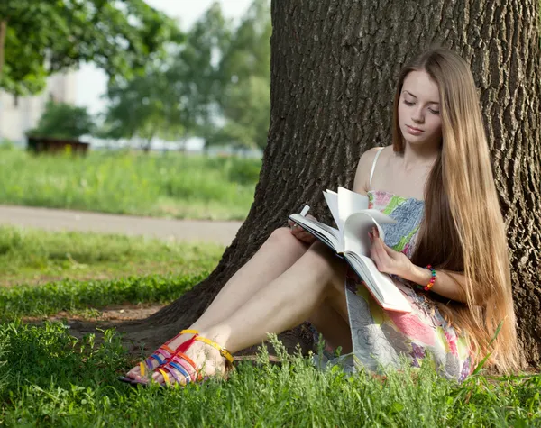 Teenager in a park with notebook Stock Picture