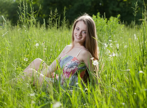 Adolescente chica sentada en la hierba — Foto de Stock