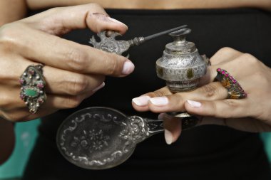 Woman holding an antique Middle Eastern make-up bottle clipart
