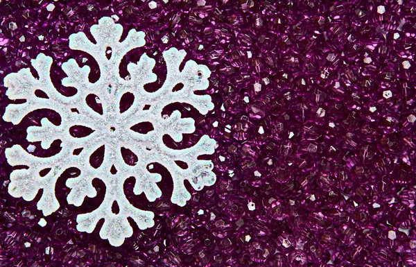 Snowflake on purple beads — Stock Photo, Image