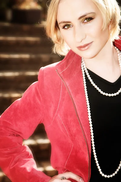Jeune femme blonde en veste rouge — Photo