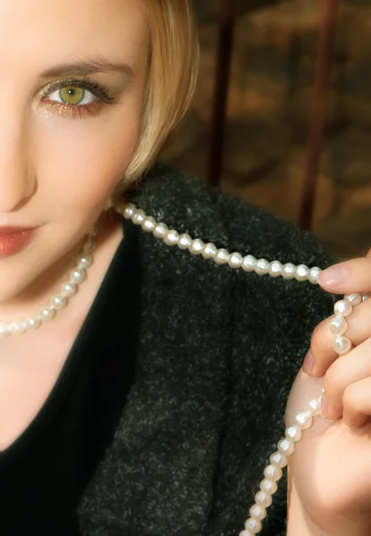 Giovane donna bionda in giacca di lana grigia e perle — Foto Stock