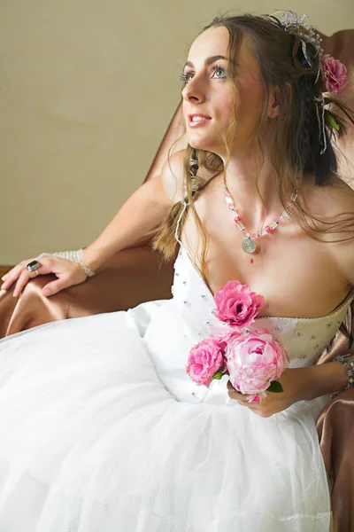 Невеста с длинными коричневыми волосами сидит в кресле — стоковое фото