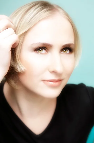 Tänkande ung blond kvinna med gröna ögon — Stockfoto