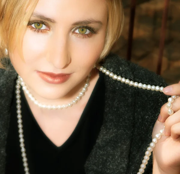 Ung blond kvinna i grå ulljacka och pärlor — Stockfoto