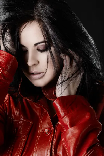Mooie vrouw met zwarte haren in rood lederen jas — Stockfoto