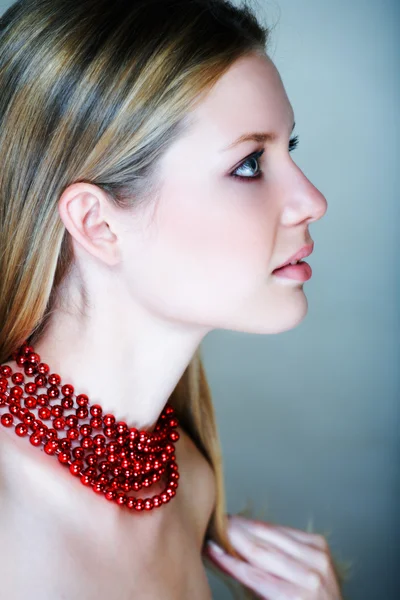 Femme blonde avec des perles rouges — Photo