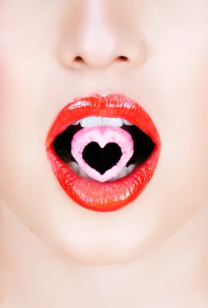 Heart candy in red lips..Heart candy in red lips. — Stock Photo, Image