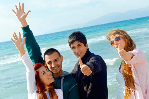 Friends with thumbs up at sea — Stock Photo, Image