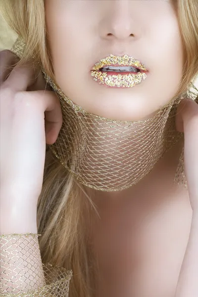 Женщина с золотым листом на губах — стоковое фото