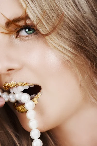 Mulher bonita com folha de ouro em seus lábios — Fotografia de Stock