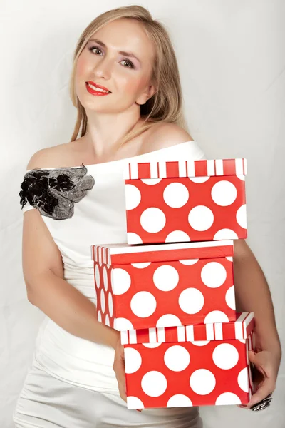 Woman in white dress and red boxes. — Stock Photo, Image