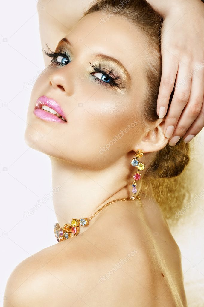 Blond woman with necklace and smile.