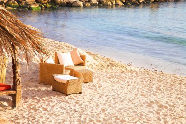 Chairs on the beach next to sea in Antibes clipart