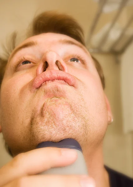 用电动剃须刀刮胡子的男人 — 图库照片