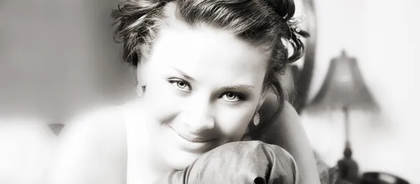 Uśmiechnięta brunetka opierając się na poduszce w sypialni — Zdjęcie stockowe