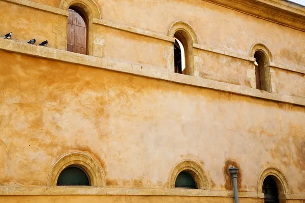 Деревенская стена с арочными окнами — стоковое фото