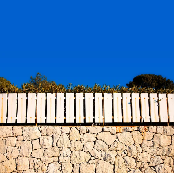 Cerca branca na parede de pedra — Fotografia de Stock