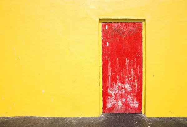 Rode deur op geel muur — Stockfoto
