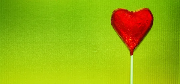 Красное сердце на зеленом — стоковое фото