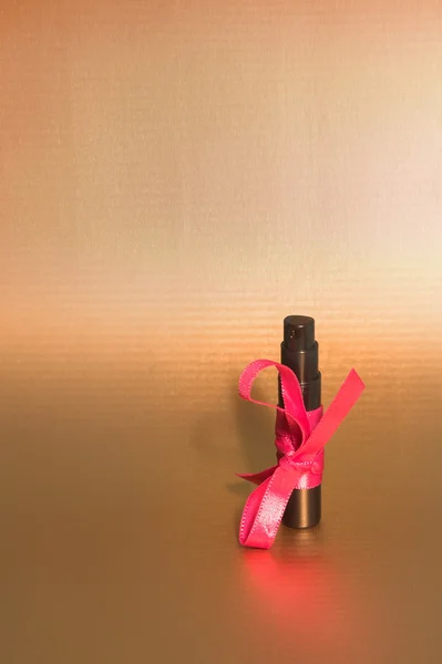 Black perfume bottle and pink ribbon.black perfume bottle and pink ribbon. — Stock Photo, Image