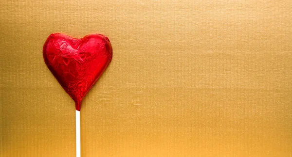 Rött hjärta godis på guld — Stockfoto