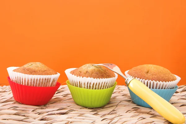 Three vanilla muffins in plastic cups — Stock Photo, Image