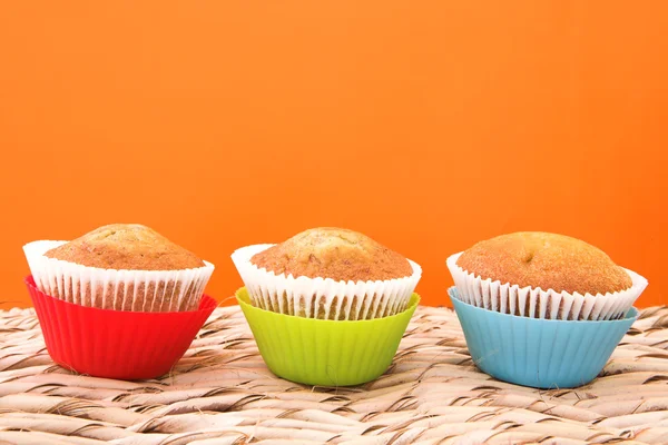Three vanilla muffins in plastic cups — Stock Photo, Image