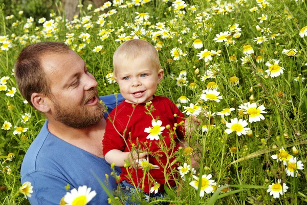 Father and son in flowers — Stock Photo, Image