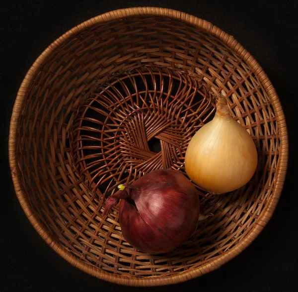 stock image Basket with onions on a black background