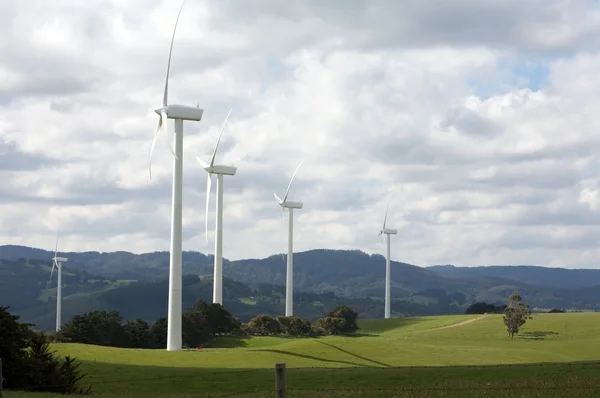Krásná zelená louka s větrné elektrárny vyrábějící elektřinu — Stock fotografie