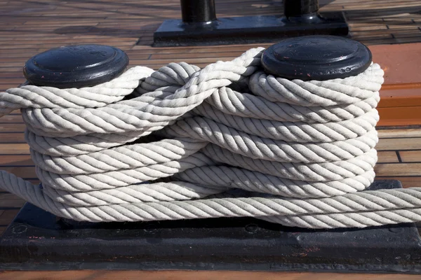 Old ropes around mooring bollard in a deck — Stock Photo, Image