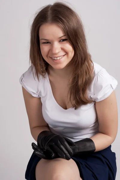 Девушка сидит в светлой рубашке и черных перчатках — стоковое фото