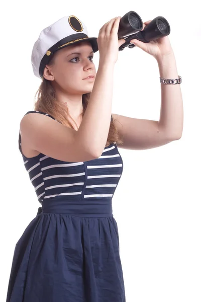 Uma menina em um chapéu de marinheiro olha através de binóculos — Fotografia de Stock