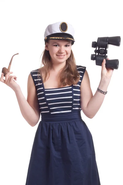 A girl in a sailor cap holding a pair of binoculars and a pipe for smoking — Stock Photo, Image