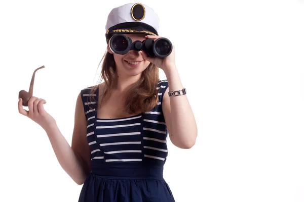 Дівчина в шапочці моряка тримає трубу для куріння і дивиться через бінокль — стокове фото
