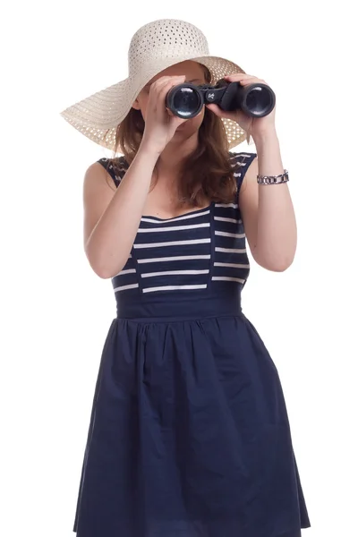 A girl in a big straw hat looking through binoculars — Stock Photo, Image