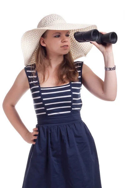 Uma menina com um grande chapéu de palha olhando através de binóculos — Fotografia de Stock