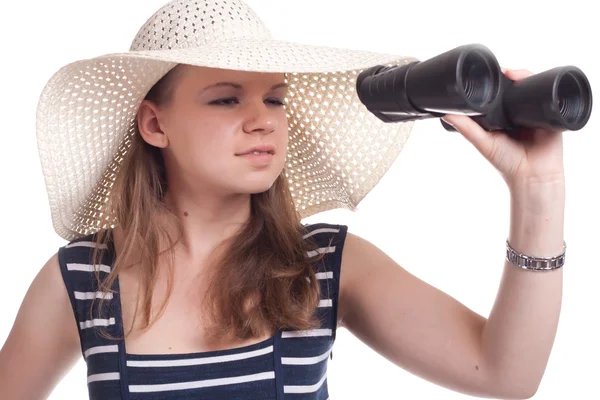 A girl in a big straw hat looking through binoculars — Stock Photo, Image