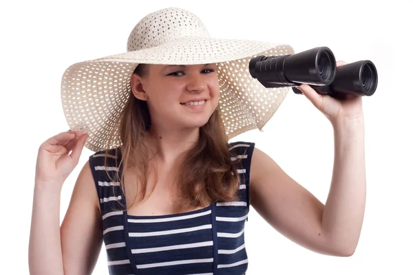Uma menina em um chapéu de marinheiro olha através de binóculos — Fotografia de Stock