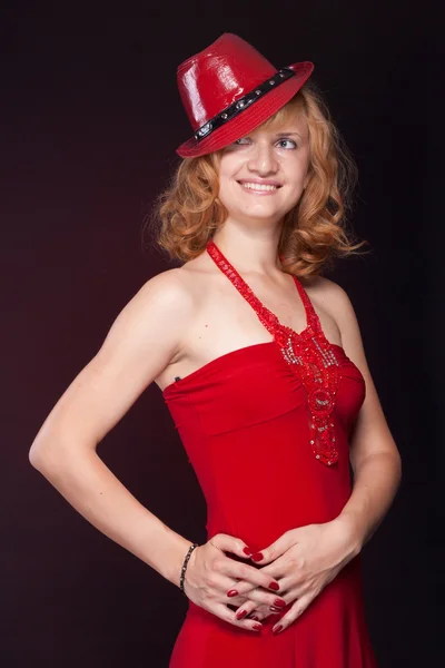 Κοκκινομάλλα κοπέλα σε ένα κόκκινο φόρεμα και κόκκινο καπέλο — Φωτογραφία Αρχείου
