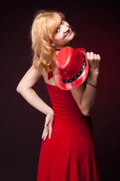Chica pelirroja en un vestido rojo y sombrero rojo — Foto de Stock