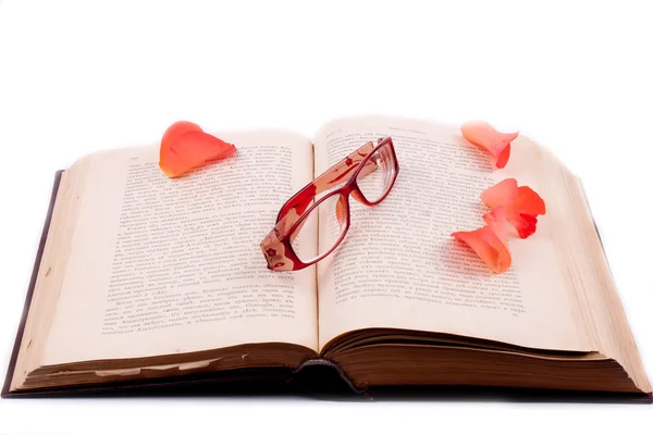 Das aufgeschlagene Buch mit Gläsern und Rosenblättern — Stockfoto