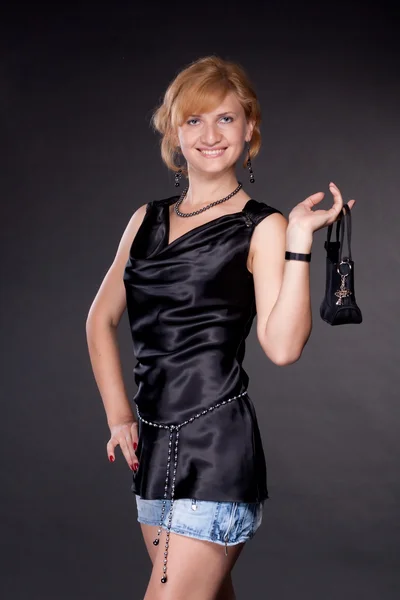 A menina, vestida de preto com um saco — Fotografia de Stock