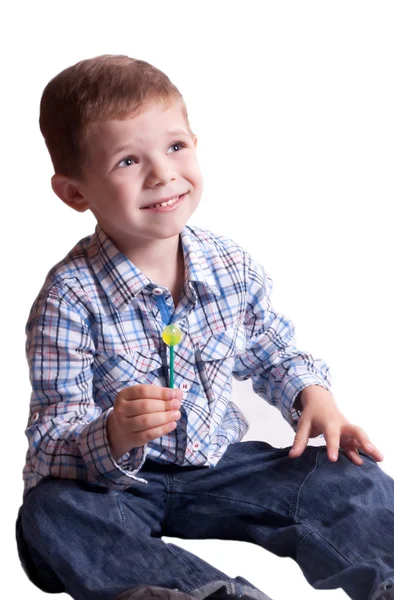 Rapaz sorridente com um chupa-chupa na mão — Fotografia de Stock