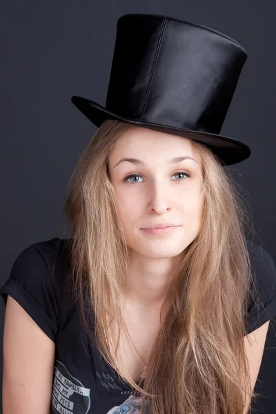 Hermosa chica sonriente en un sombrero negro — Foto de Stock