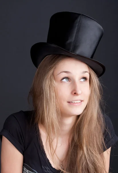 Beautiful smiling girl in a black hat — Stock Photo, Image